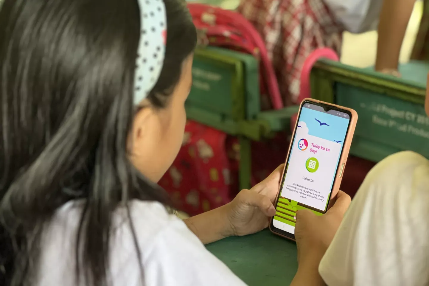 A child with a mobile checking OKY app