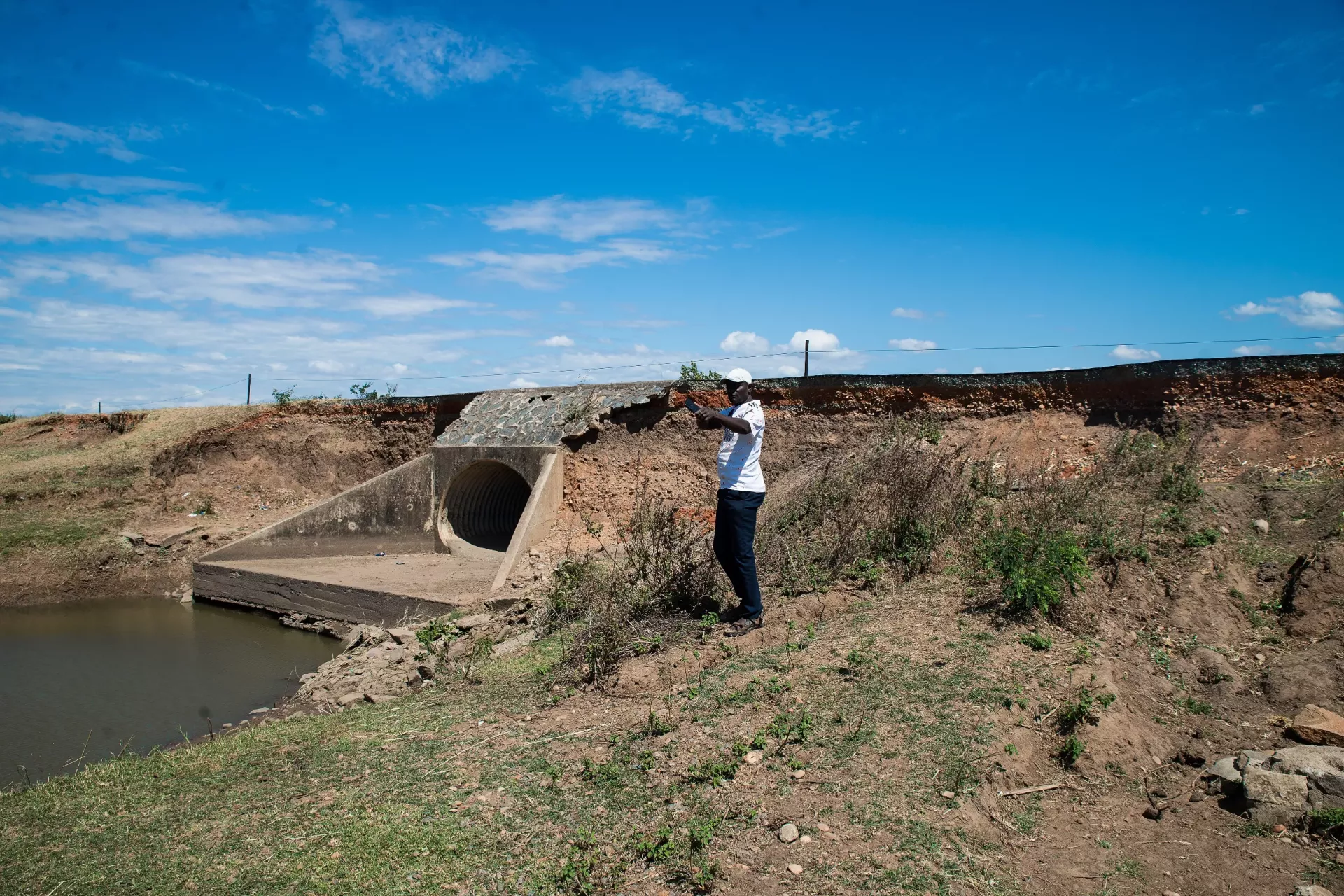 During the Media tour for IBF EWS Project organized by UNICEF on Thursday 27th of June 2024, Karonga District Meteorological Officer, Victor Phiri is seen reading data on the Automatic Weather Station meter at Karonga Airport in the Northern part of Malawi.