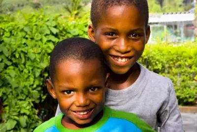 Ni&ntilde;os abrazados y sonriendo.