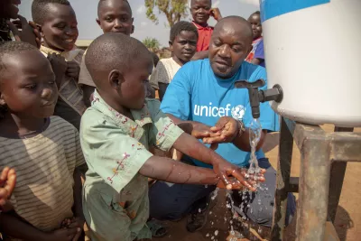 Jean Marie Bofio montre &agrave; des enfants comment correctement se laver les mains.