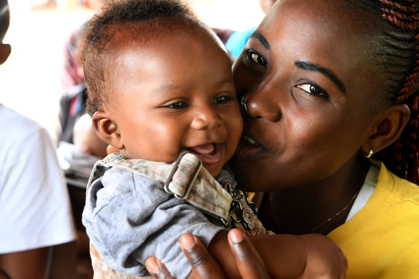 Une m&egrave;re qui embrasse son b&eacute;b&eacute; sur la joue