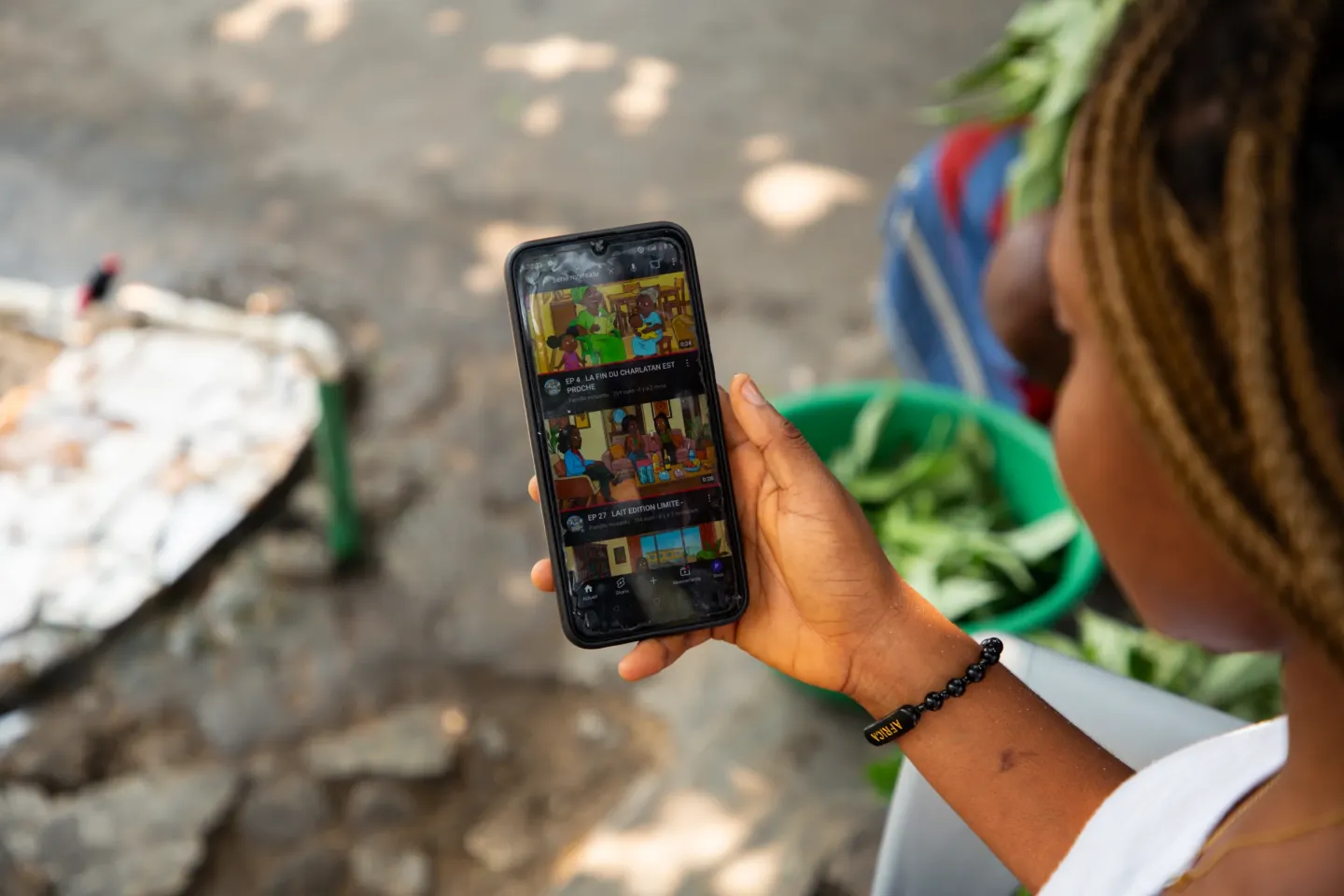 Une jeune fille regarde la serie mosantu via son t&eacute;l&eacute;phone