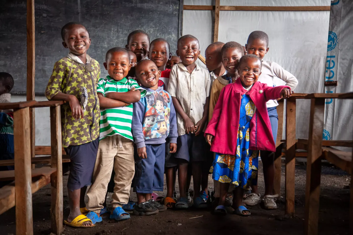 Un groupe d'enfants se tient debout dans une salle de classe temporaire install&eacute;e par l'UNICEF.