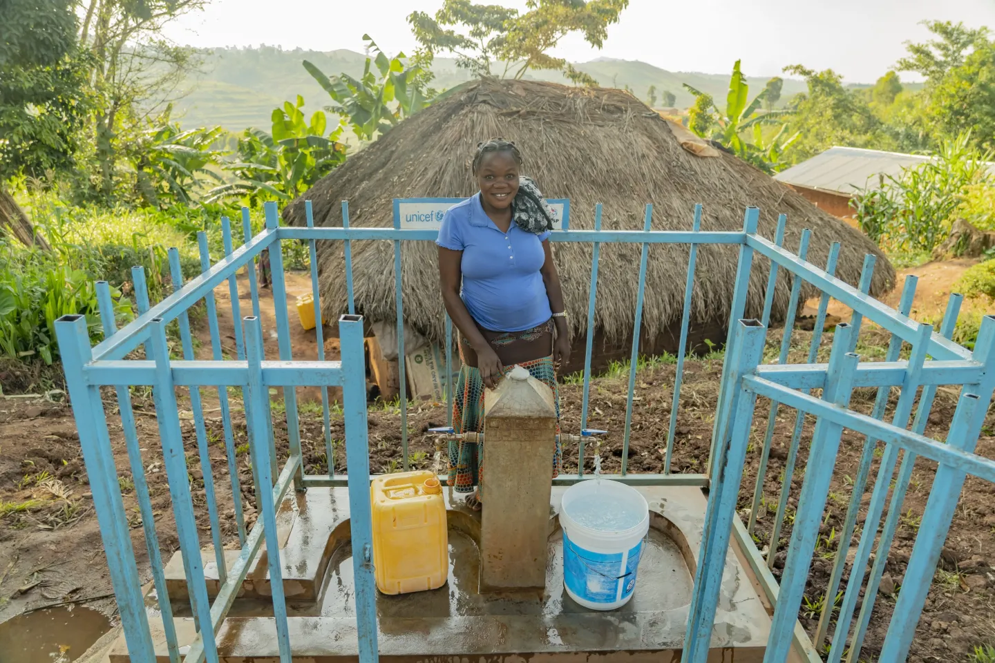 Une femme se tient &agrave; une borne fontaine