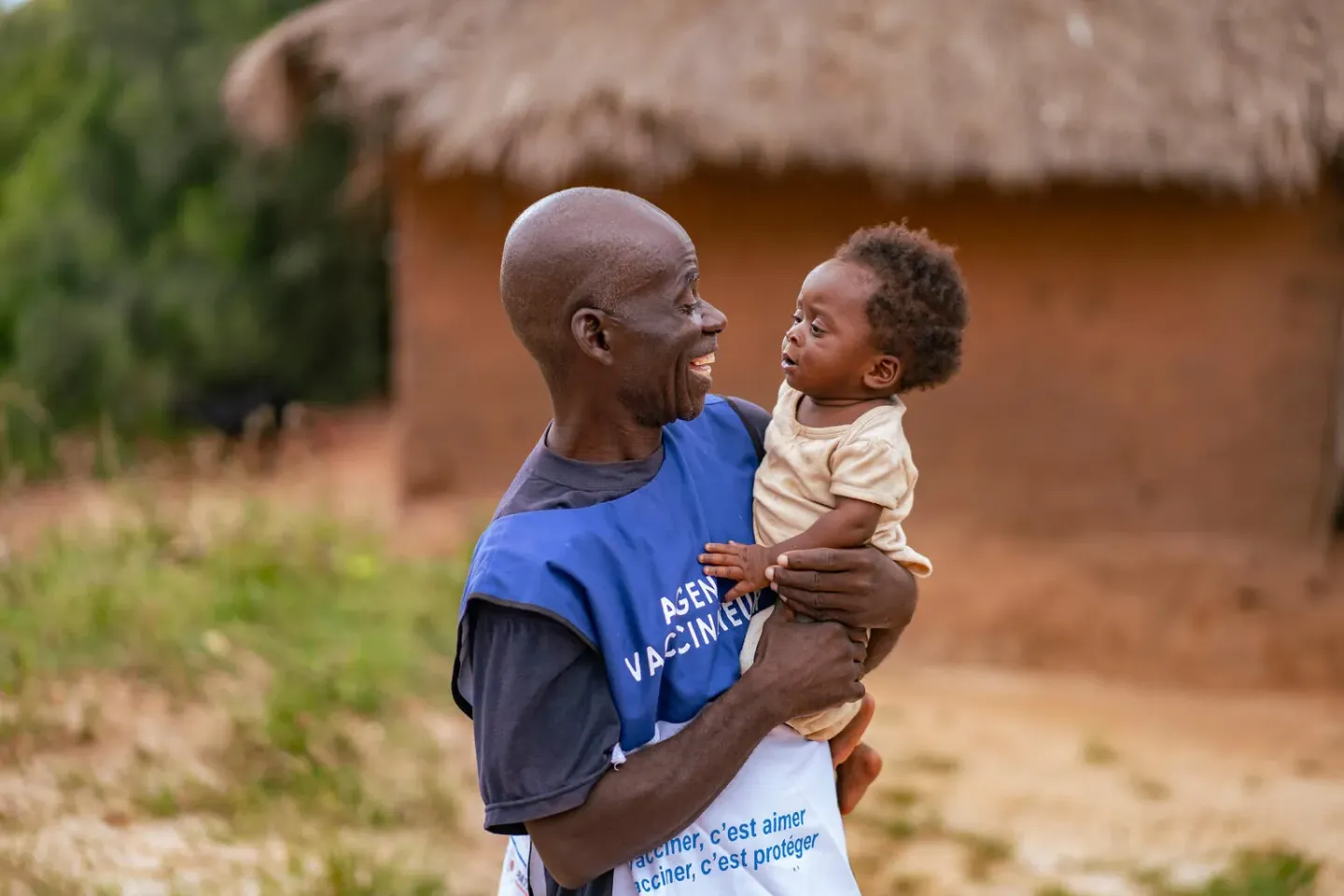 A vaccinator holding a baby
