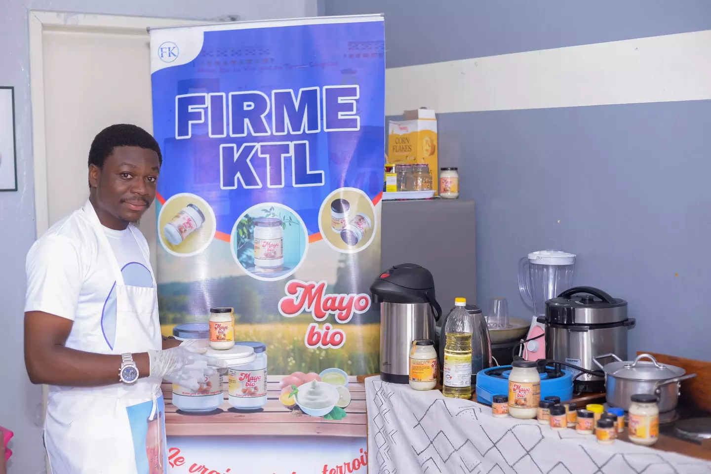 Un jeune homme tient un pot de mayonnaise sur une balance dans ses mains