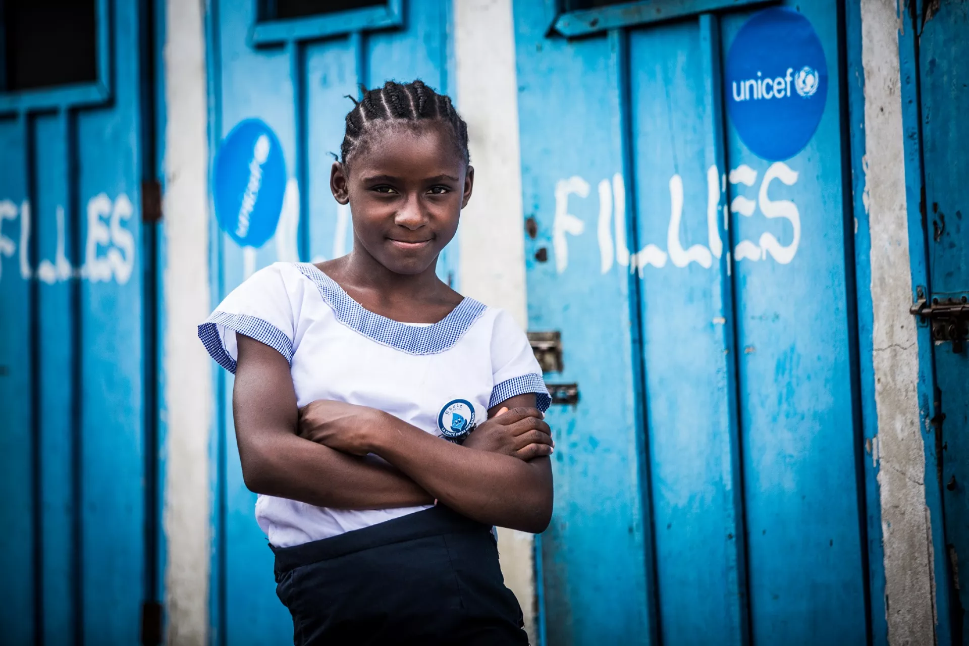 Une fille devant des latrines en RDC