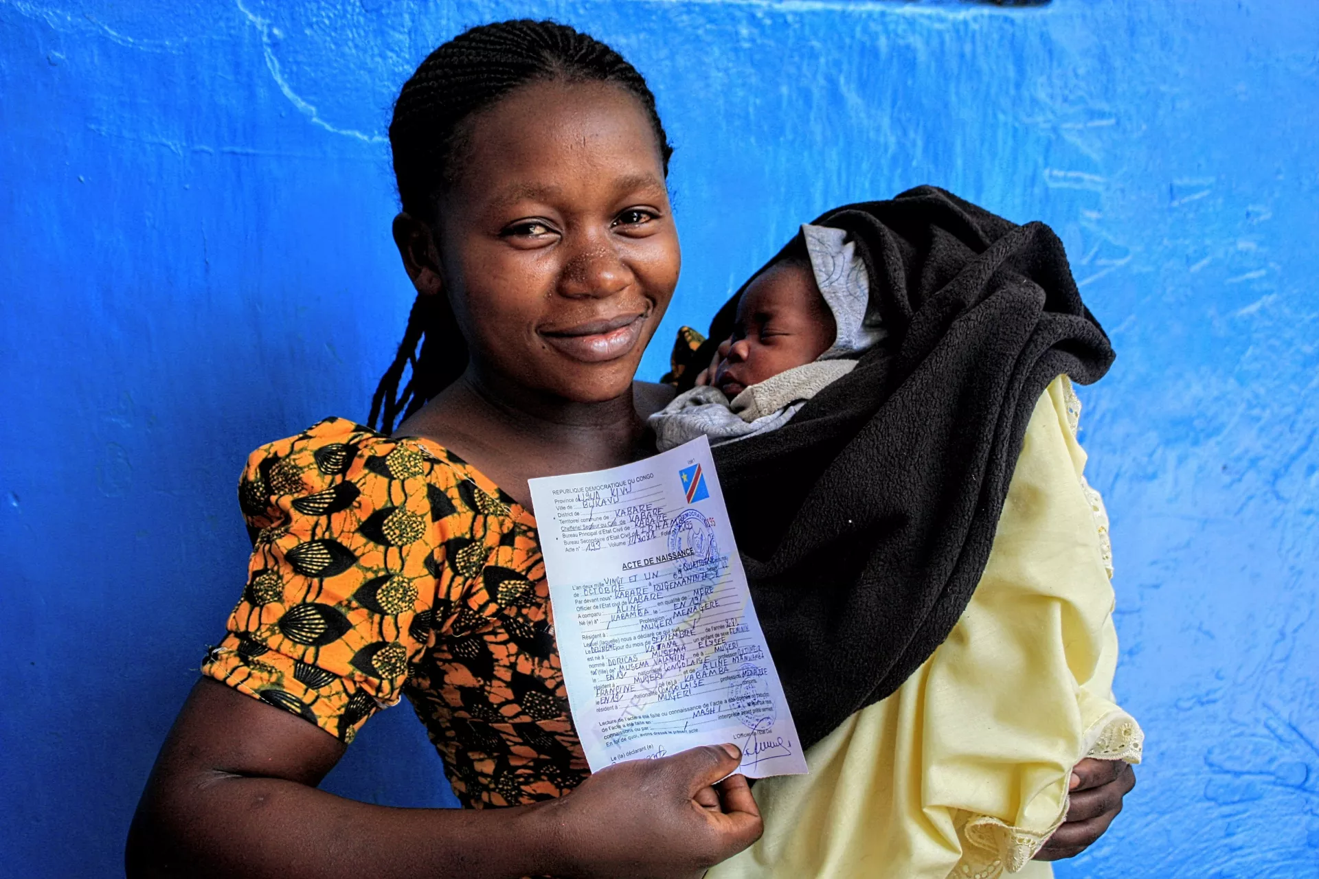 Une maman tient l'acte de naissance de son Enfant