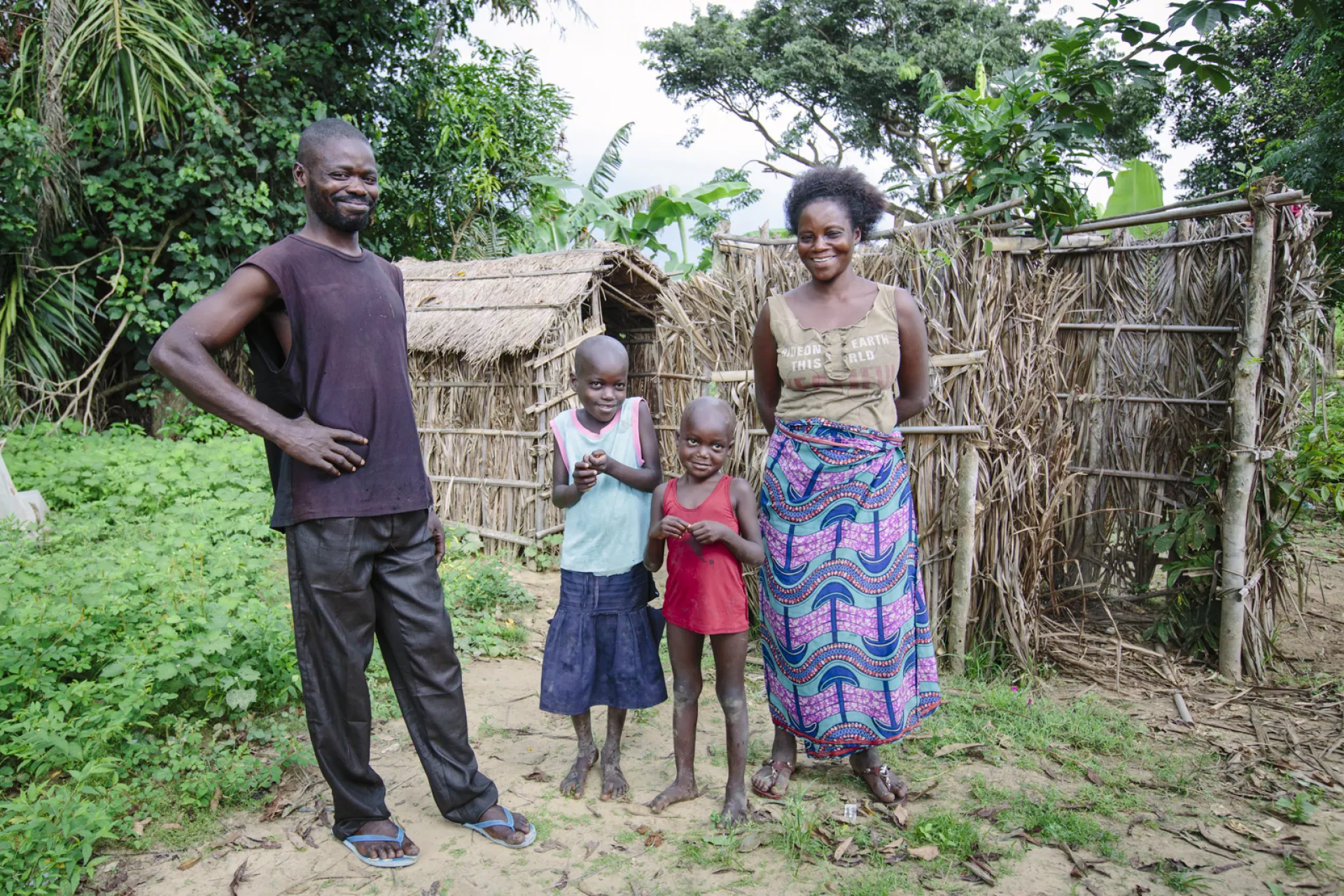 Une famille de 4 personnes devant une latrine 