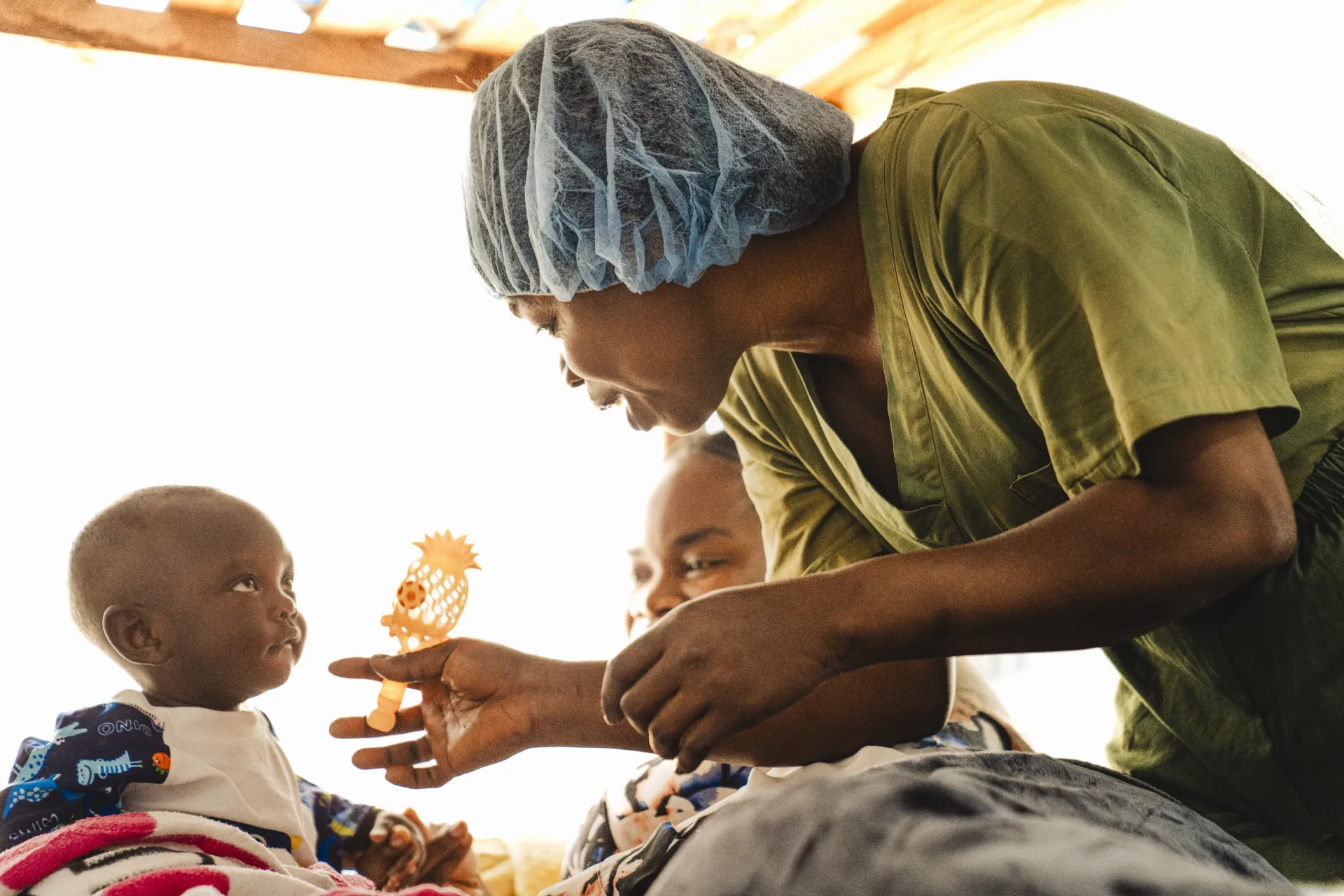 Une infirmi&egrave;re joue avec un b&eacute;b&eacute; pendant la crise li&eacute;e &agrave; Ebola en RDC.