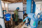 Une aide-soignante se pr&eacute;pare dans une zone de d&eacute;contamination avant d'entrer dans le centre de traitement.