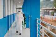 Une professionnelle de sant&eacute; en combinaison de protection marche dans un couloir du centre de traitement Ebola.