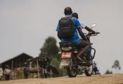 L'infirmier et l'agent communautaire de dos sur une moto