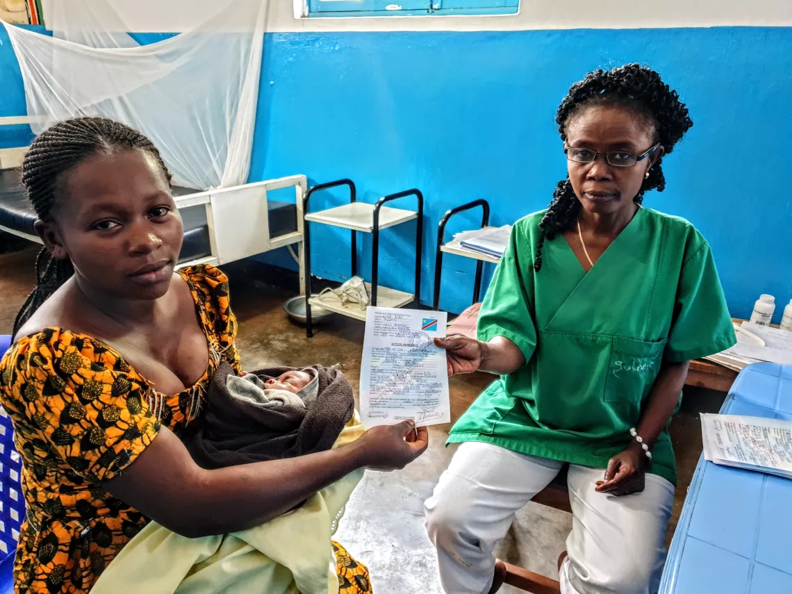 Une femme re&ccedil;oit l'acte de naissance de son enfant