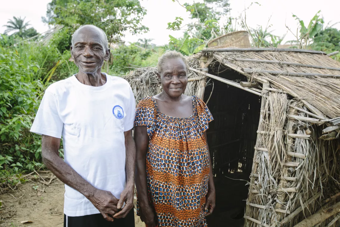 Deux personnes &acirc;g&eacute;es qui sourient devant leurs nouvelles latrines