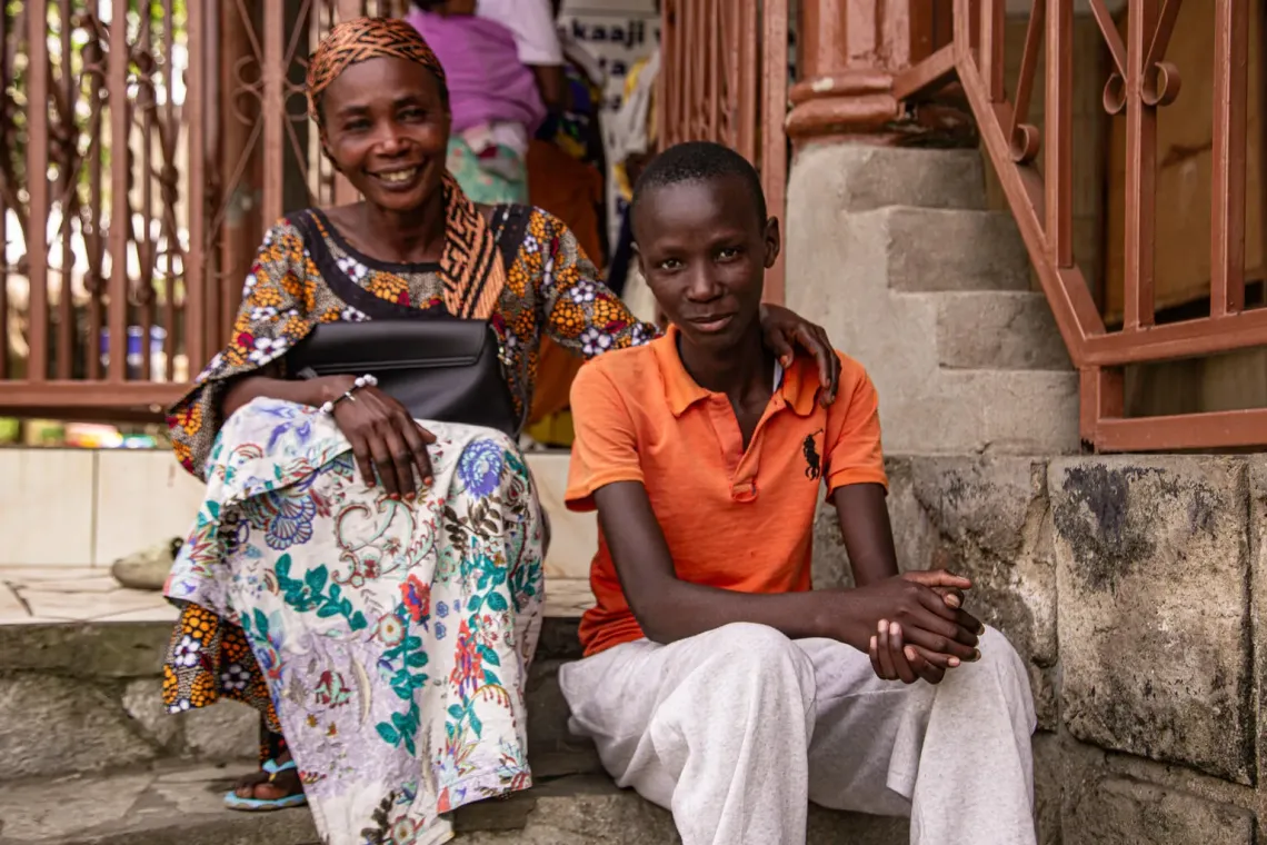 Une femme et un adolescent assis sur des marches