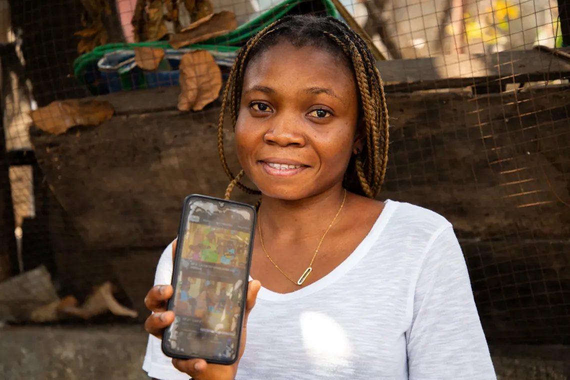 Plamedi montrant son t&eacute;l&eacute;phone avec les images de la s&eacute;rie Mosantu