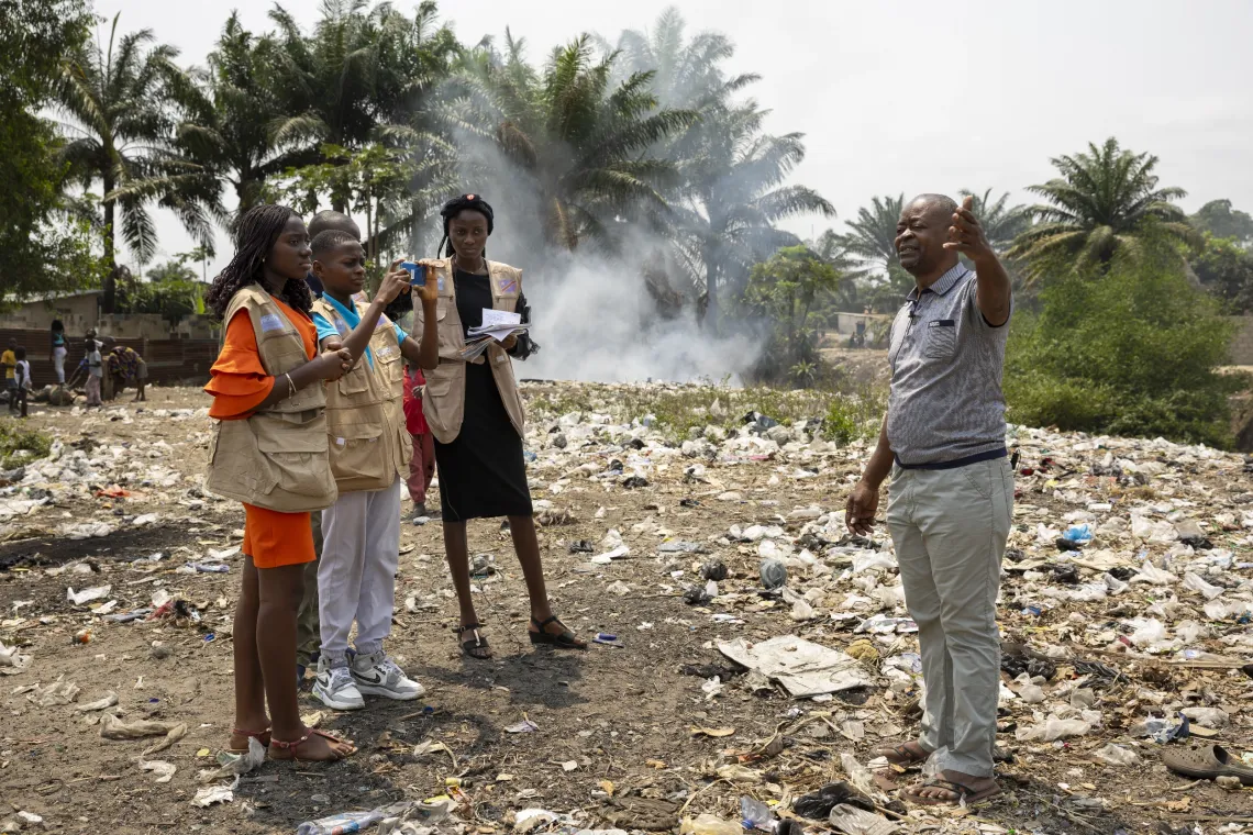 Un groupe d'enfants filment un homme qui parle