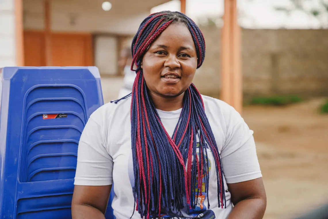 A woman standing next to plastic chairs