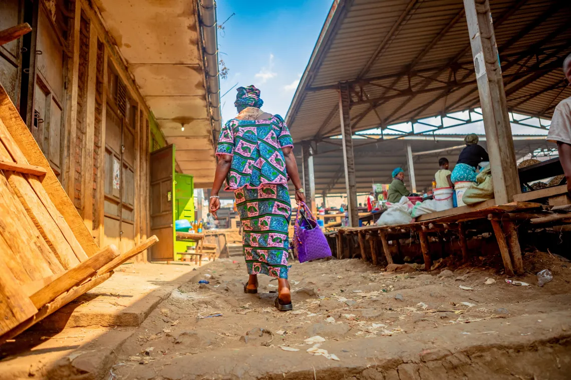 Une femme tenant un panier marche dans une all&eacute;e