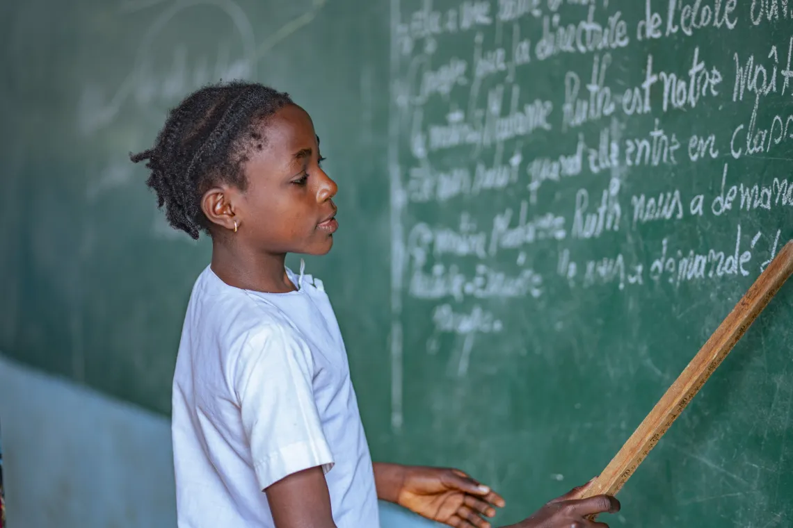 Une &eacute;l&egrave;ve tient une r&egrave;gle au tableau dans sa salle de classe