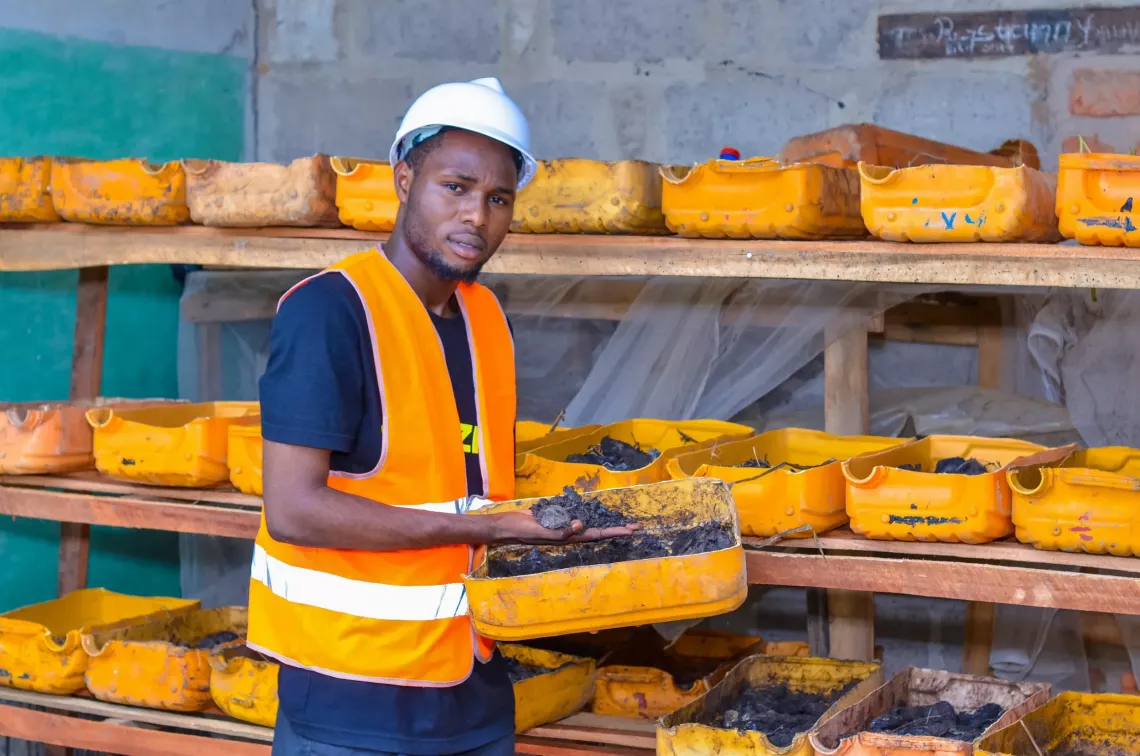 Un jeune homme tient un contenant 