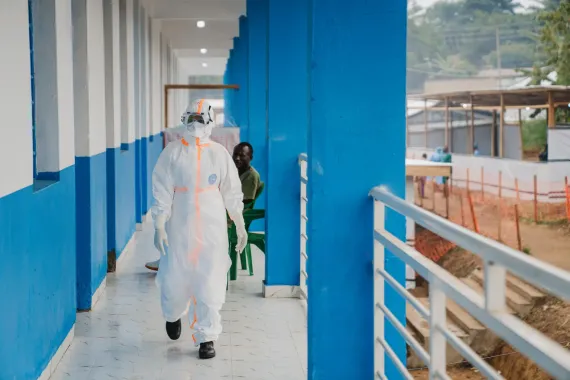 Une professionnelle de santé en combinaison de protection marche dans un couloir du centre de traitement Ebola.