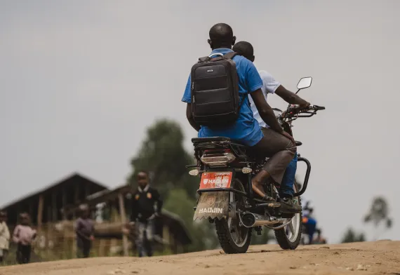 L'infirmier et l'agent communautaire de dos sur une moto