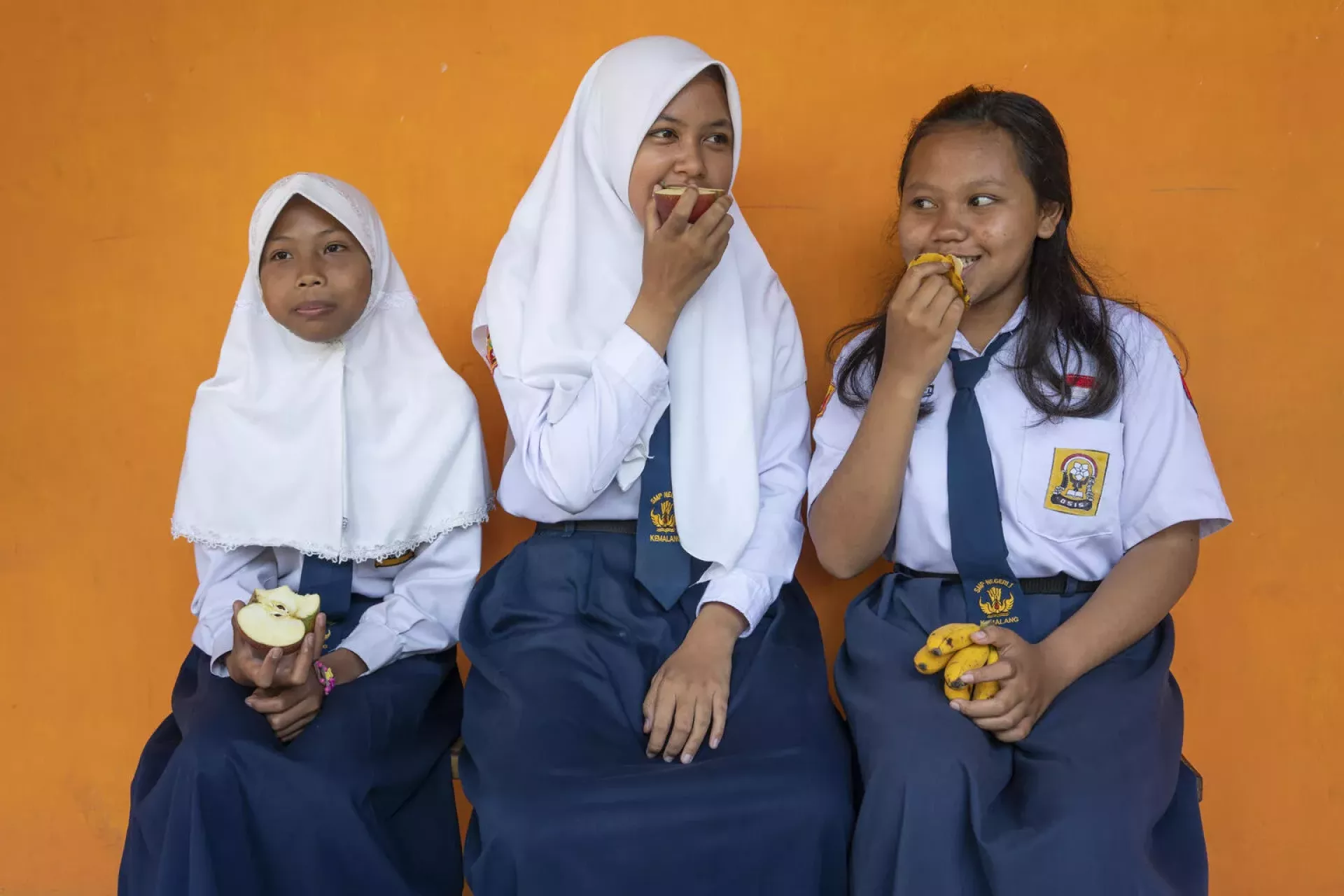State junior high school female students enjoy snacks at SMP 1 Kemalang, Klaten, Central Java, Indonesia.