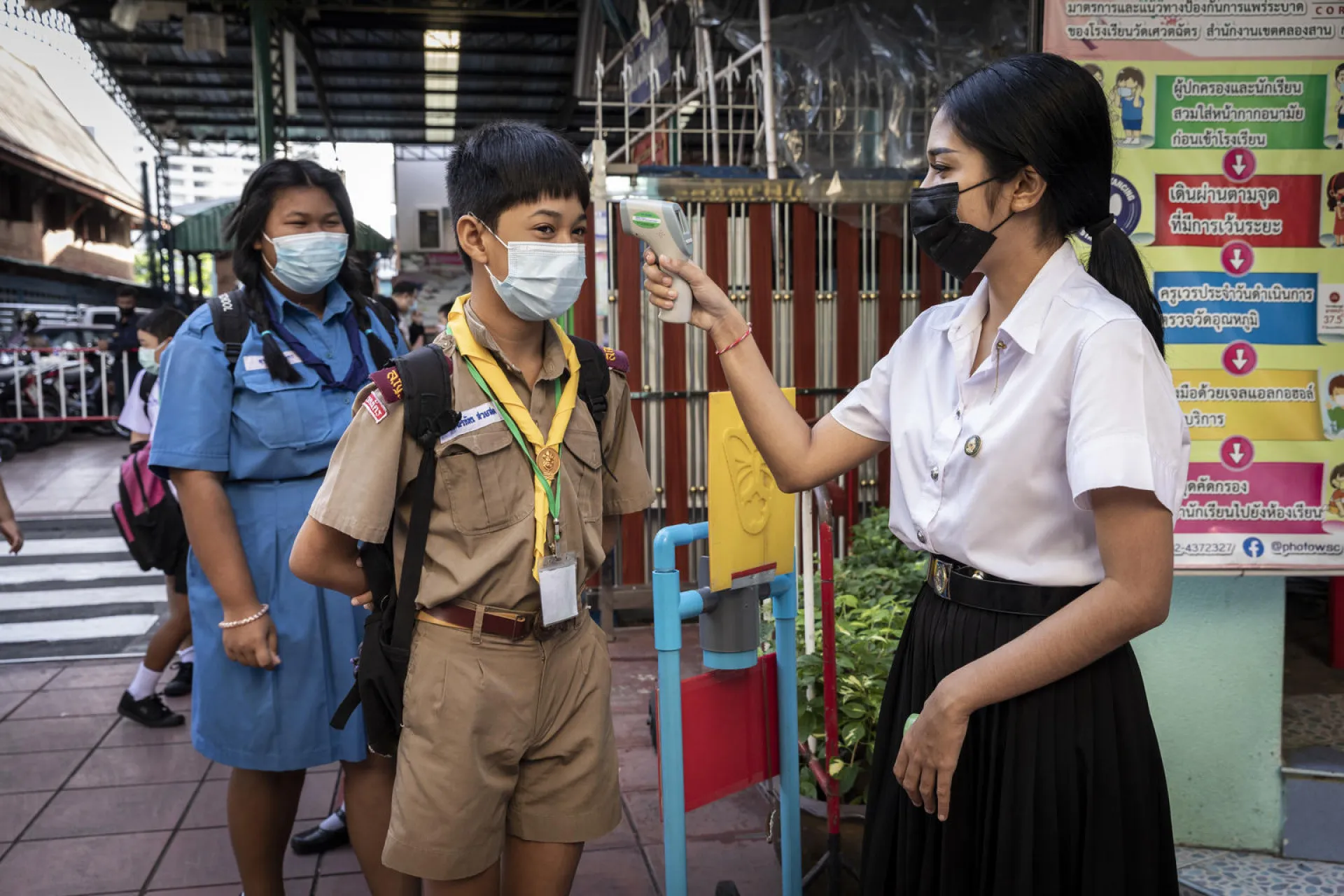 Students getting their temperature checked before entering school premises 