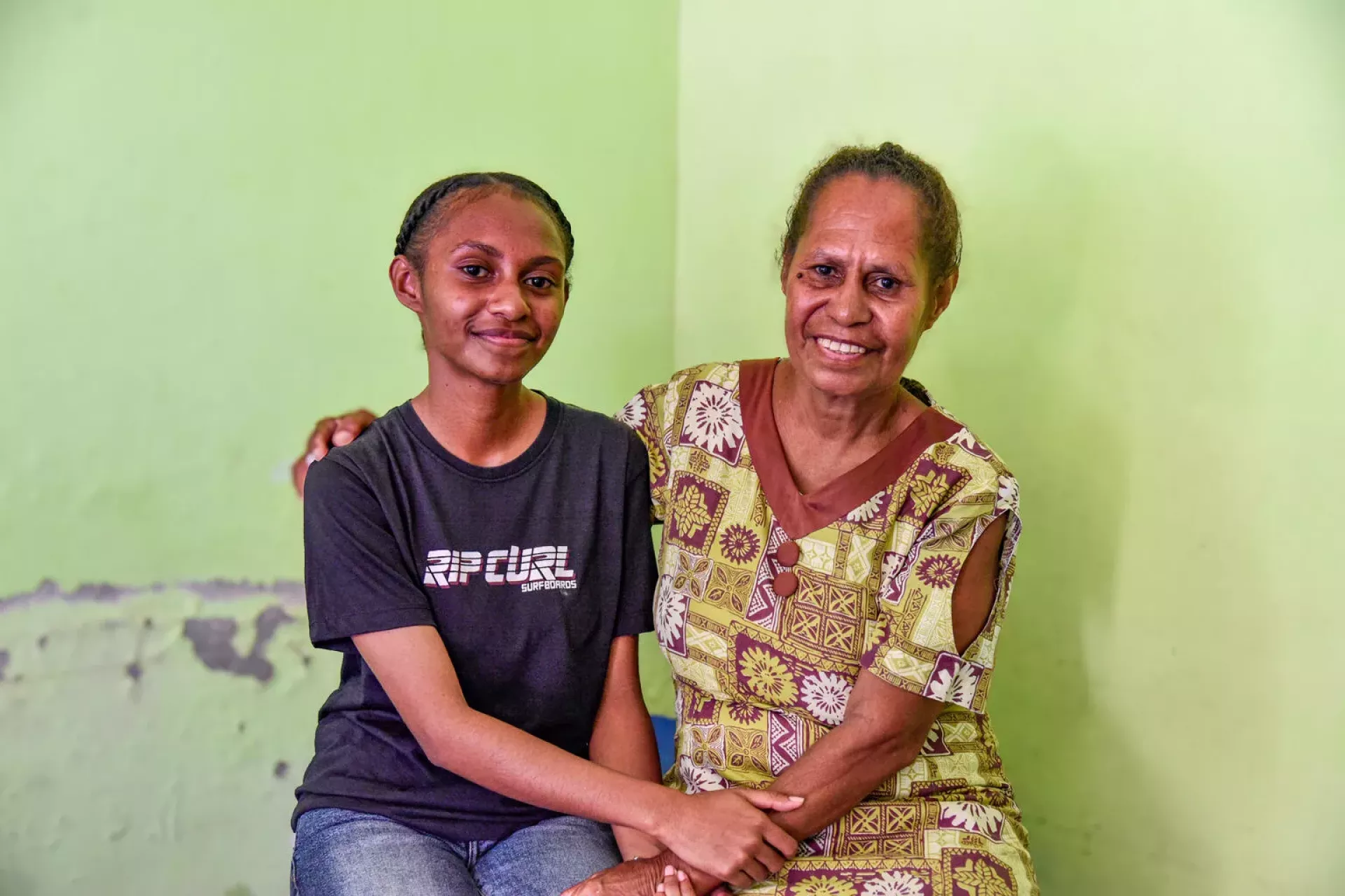 A teenage girl and her mother hold hands