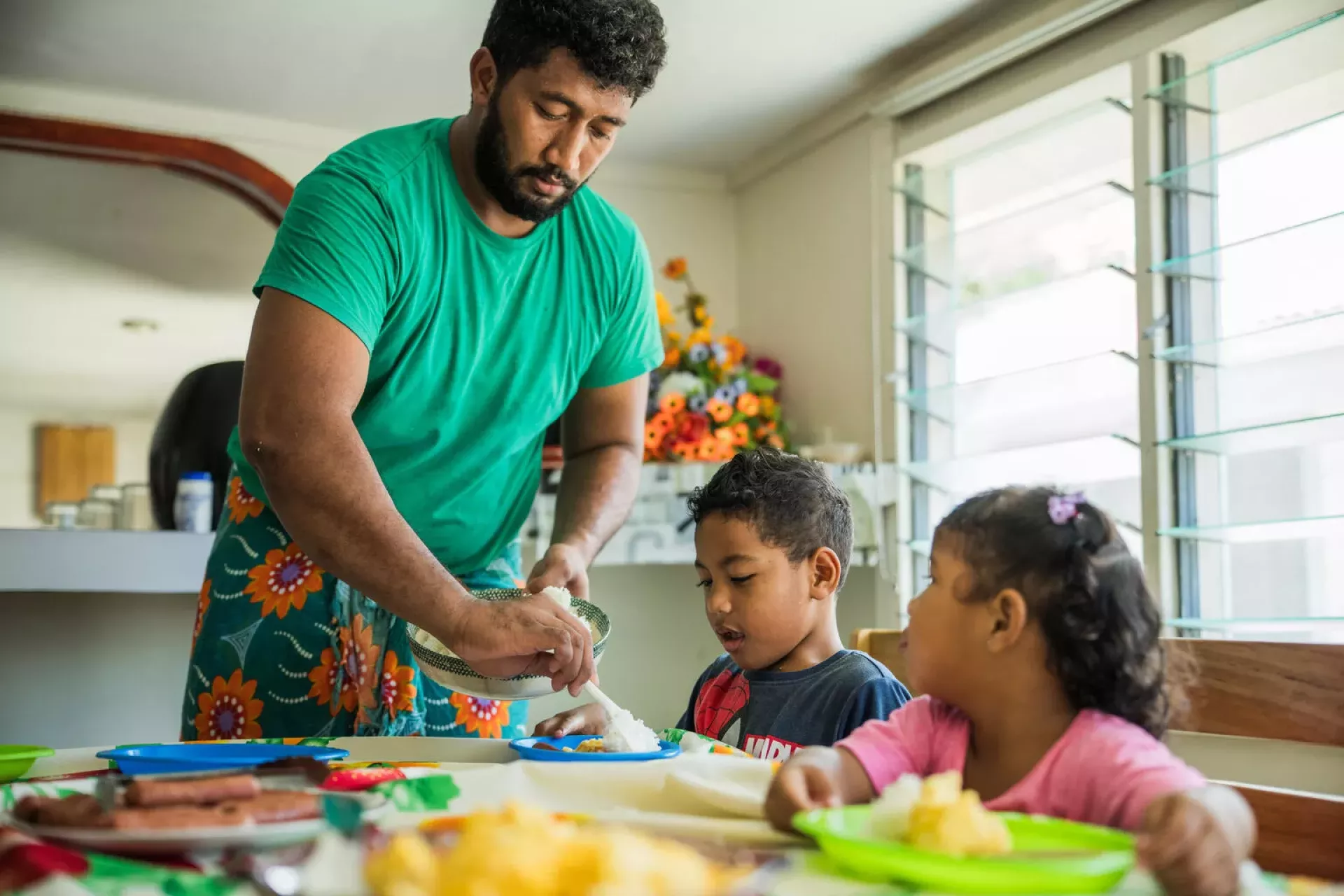 A Dad serves his children a meal