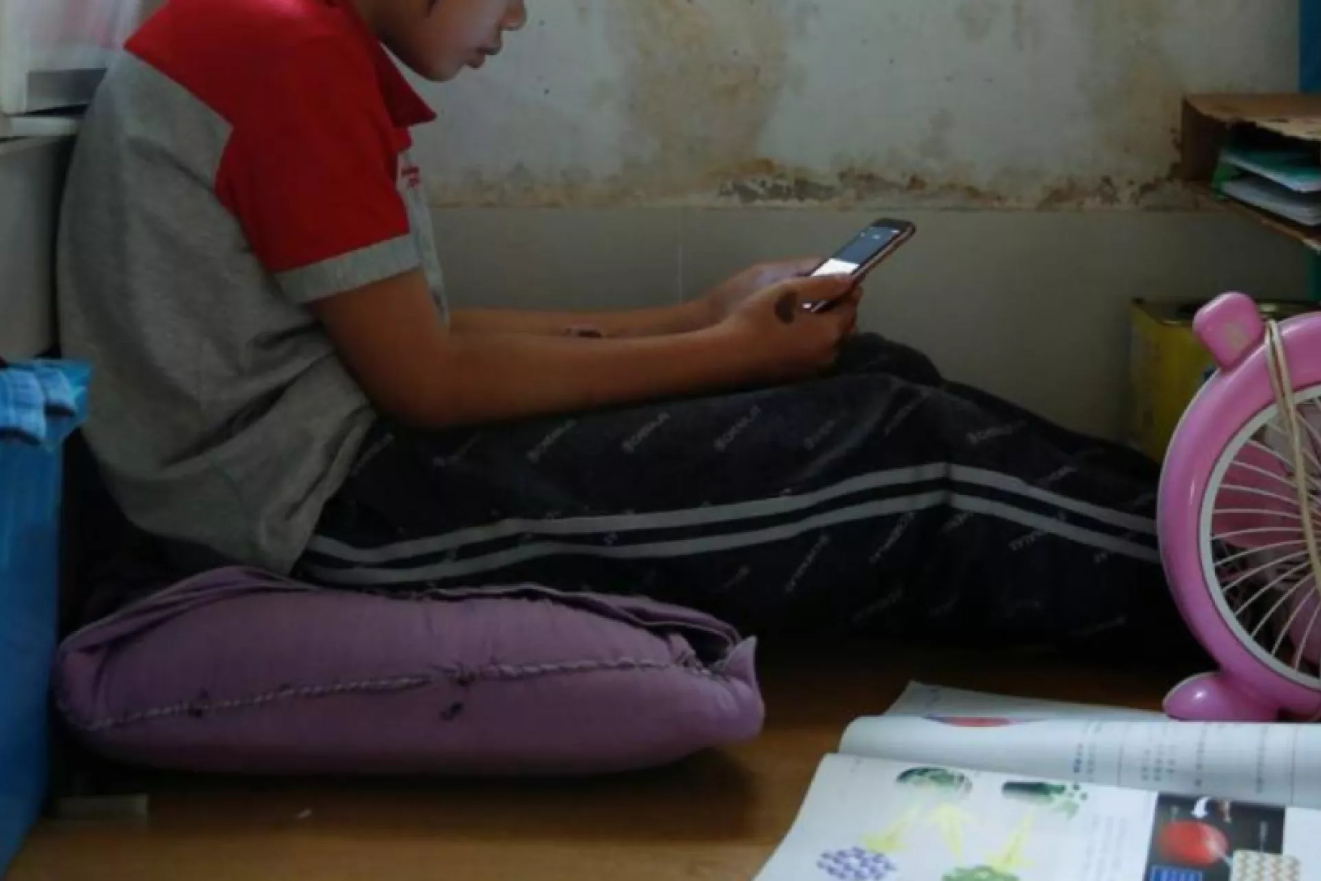 Secondary school student Wendy attends an online class with a smartphone at home during the novel coronavirus disease (COVID-19) outbreak