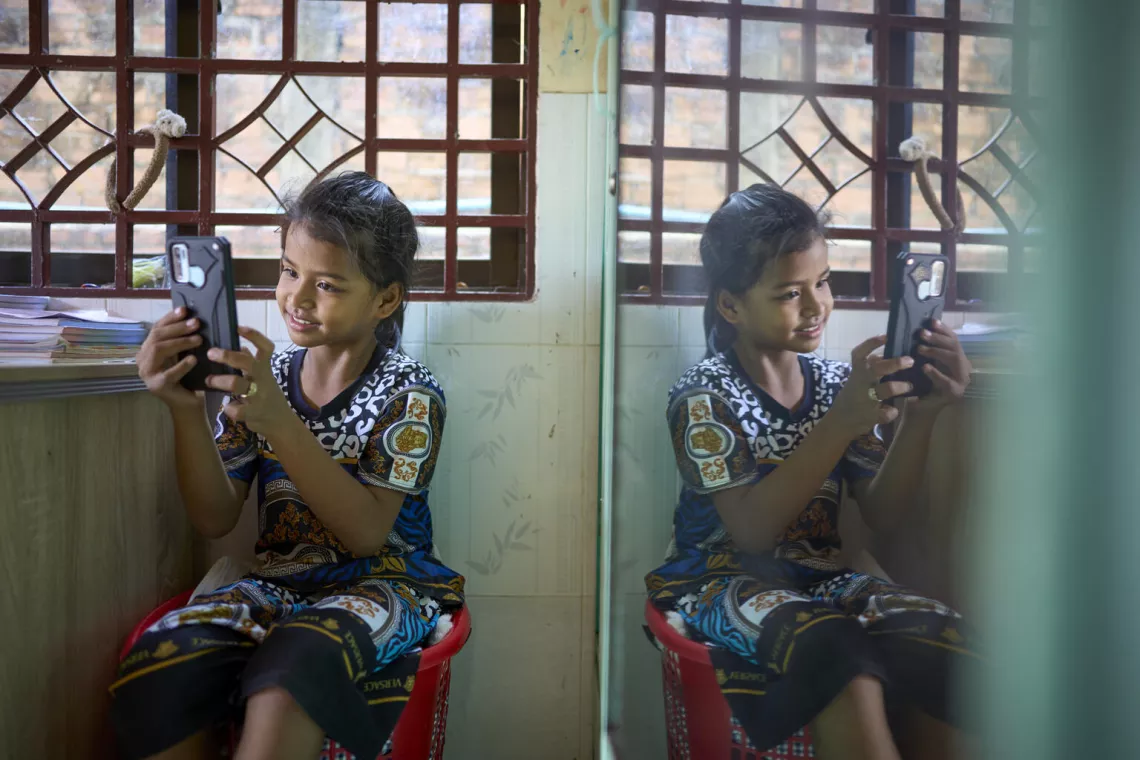 Kimheng plays with her mother's phone. She has an application to recognize letters, words and to count. Her mother finds this very beneficial to her learning.