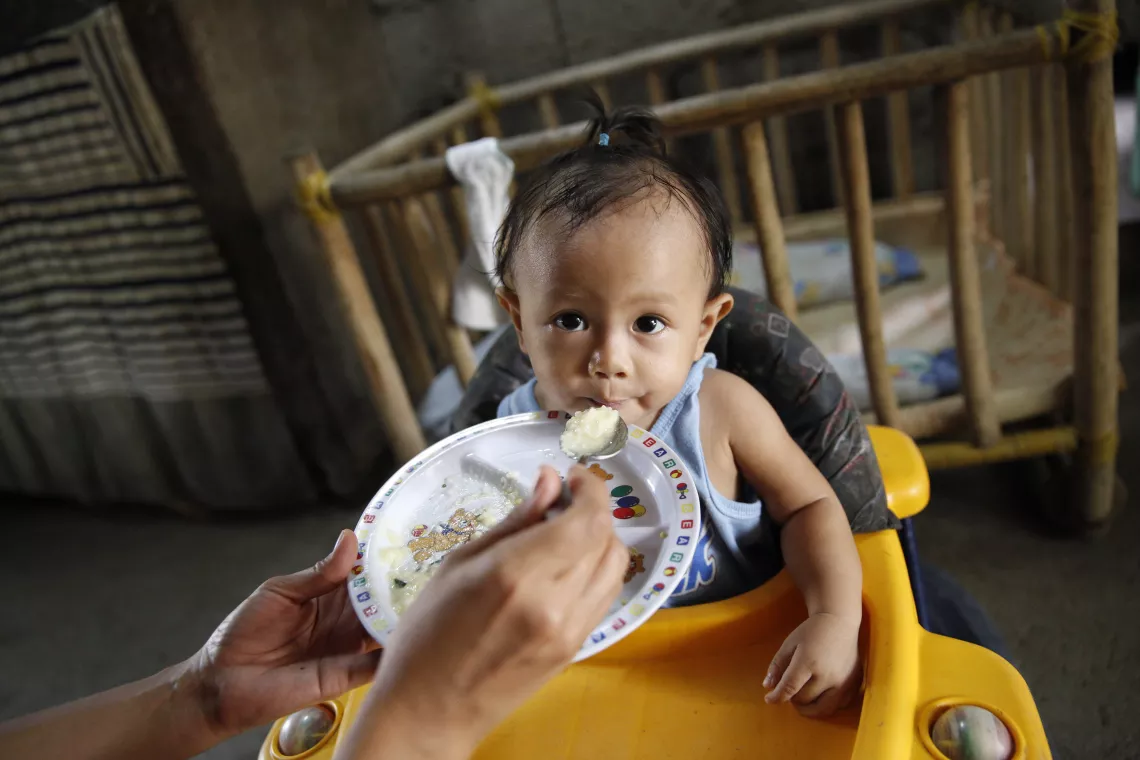 10-month old Khaizer Jay Alagaban is fed by her mother at their home in the Philippines