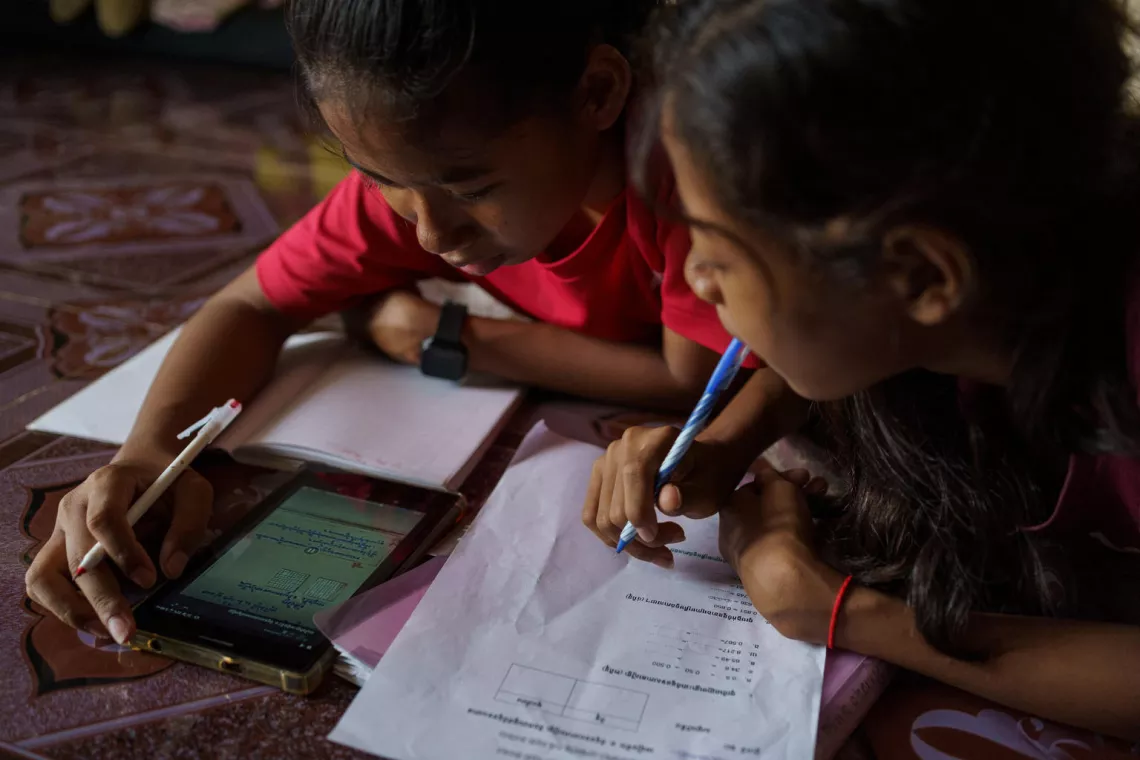Nha Nha helps her smaller sister Sopheap with her home-works using a live streaming lesson.