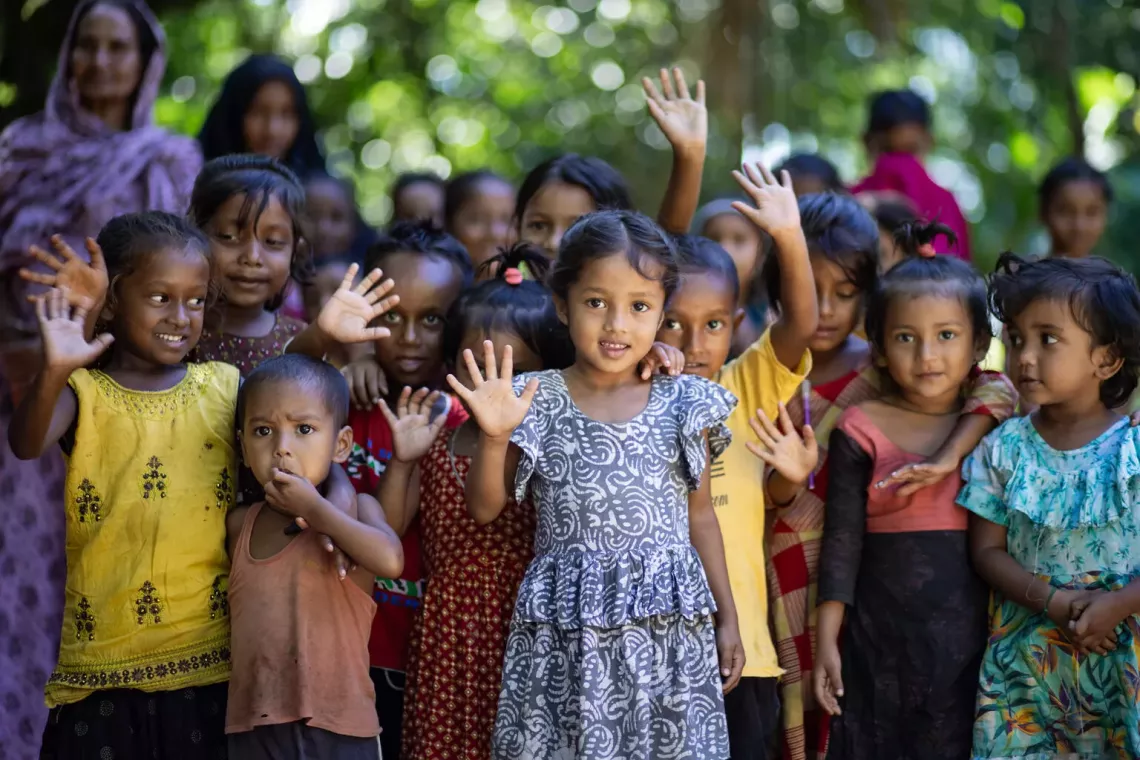 A group of young girls smiling and waving