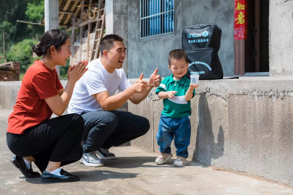 two-year-old Kaikai plays a game at home with his parents
