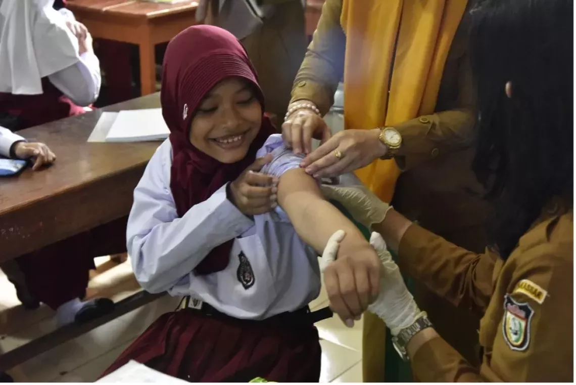 Smiles in Indonesia as a student gets the HPV vaccine at school.