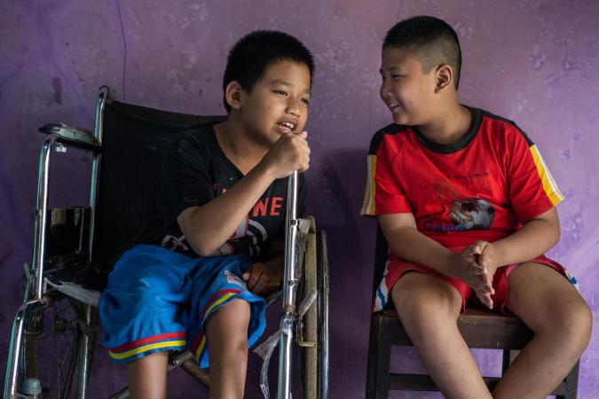 Syaiful (left), 12, a child with a physical impairment, sits next to his best friend Kevin Saputra (right), 9, a child with a visual impairment, at Syaiful's house in Banyumas, Central Java, Indonesia. 