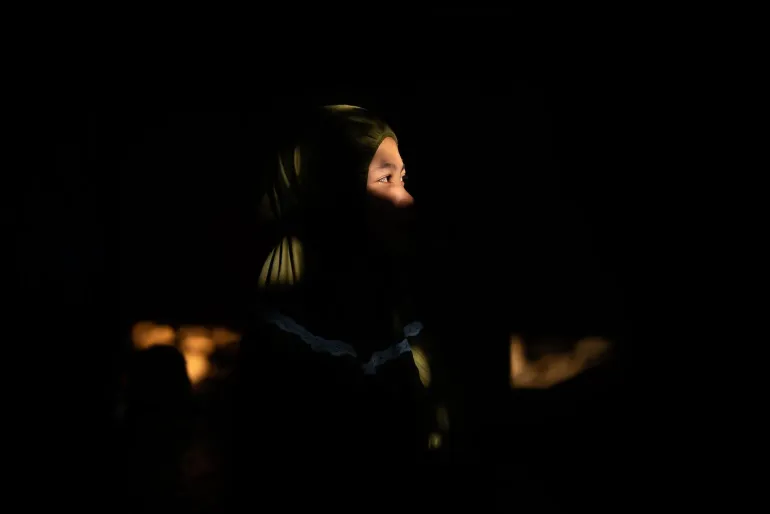A girl sitting in the dark