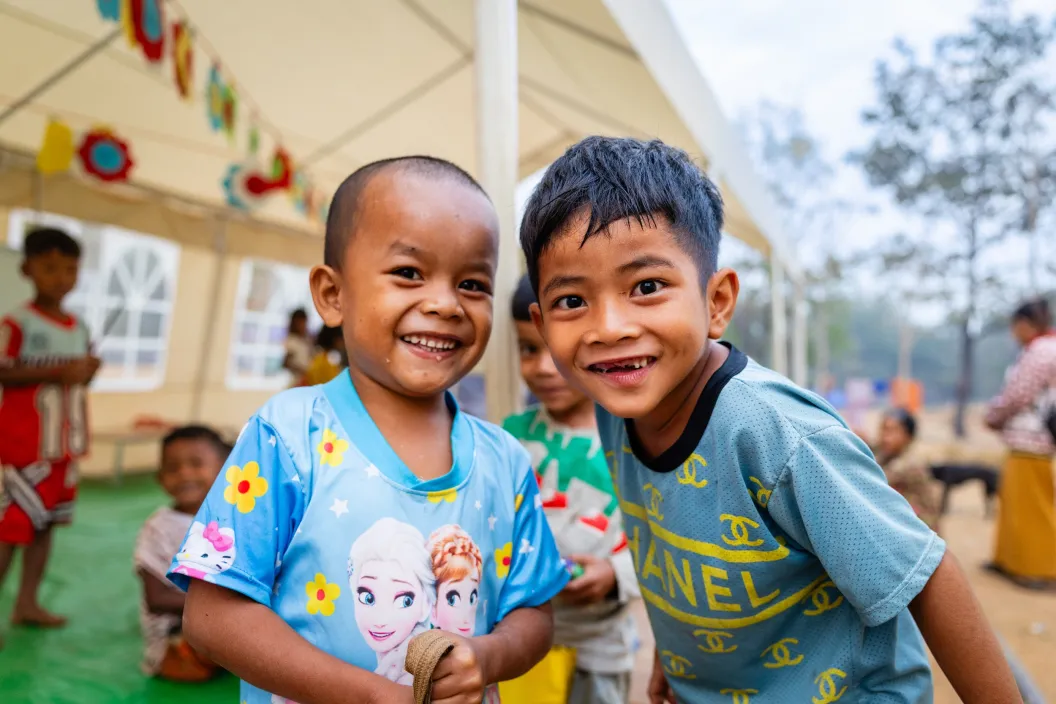 Two preschool students smile for the camera.