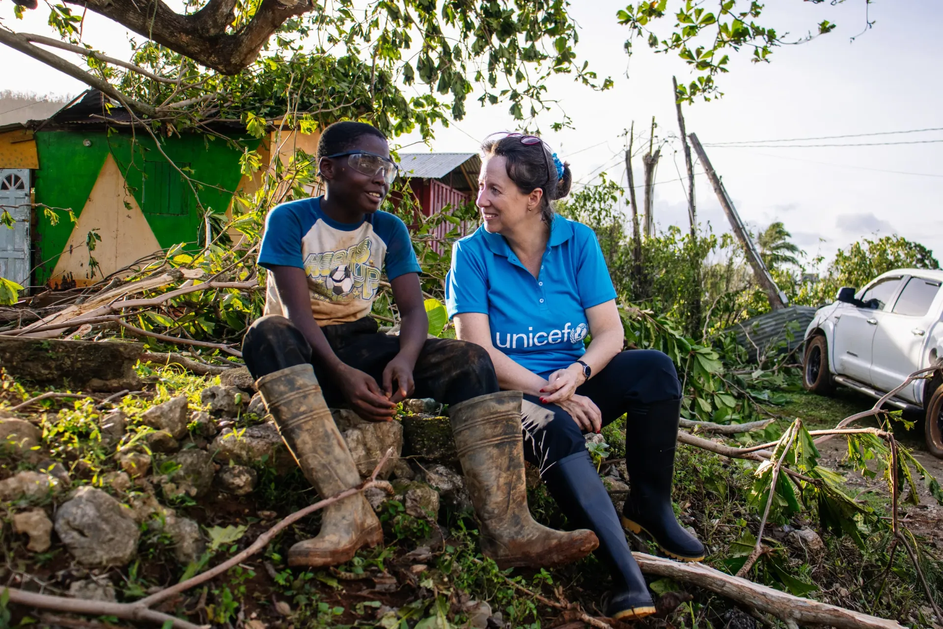 Photo of child with UNICEF rep in aftermath of a hurricane
