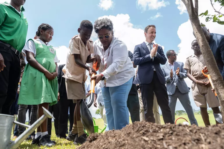 Mia Mottley planting a tree with a child in Barbados 