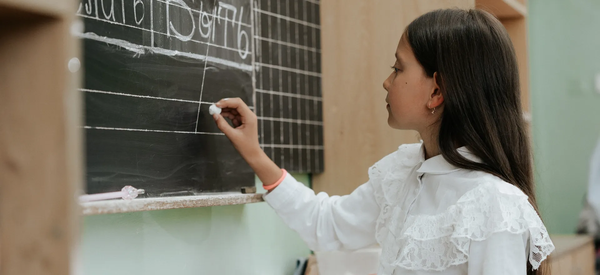 Ten-year-old Darya from Ukraine writes on the blackboard. 