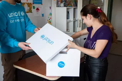 Young mother, a refugee from Ukraine currently living in Budapest, Hungary is unpacking the UNICEF Baby Box