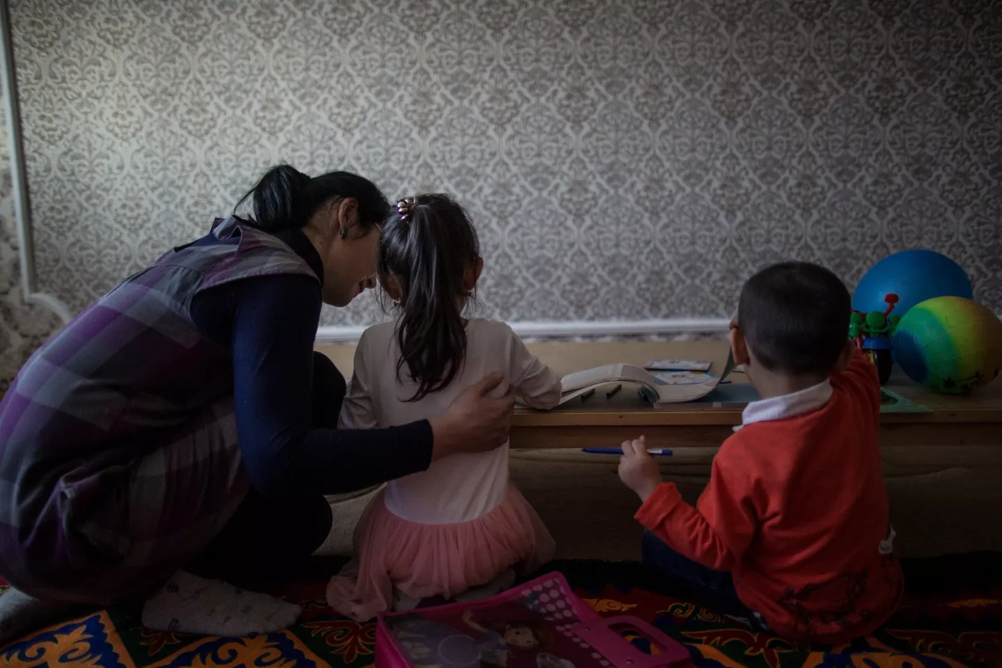 Patronage nurse Dinara Akhmetova plays with Anelya, age 5, and Arsen, age 3, in the living room of the children&rsquo;s family apartment in Kyzylorda, Kazakhstan. 12 March 2018.