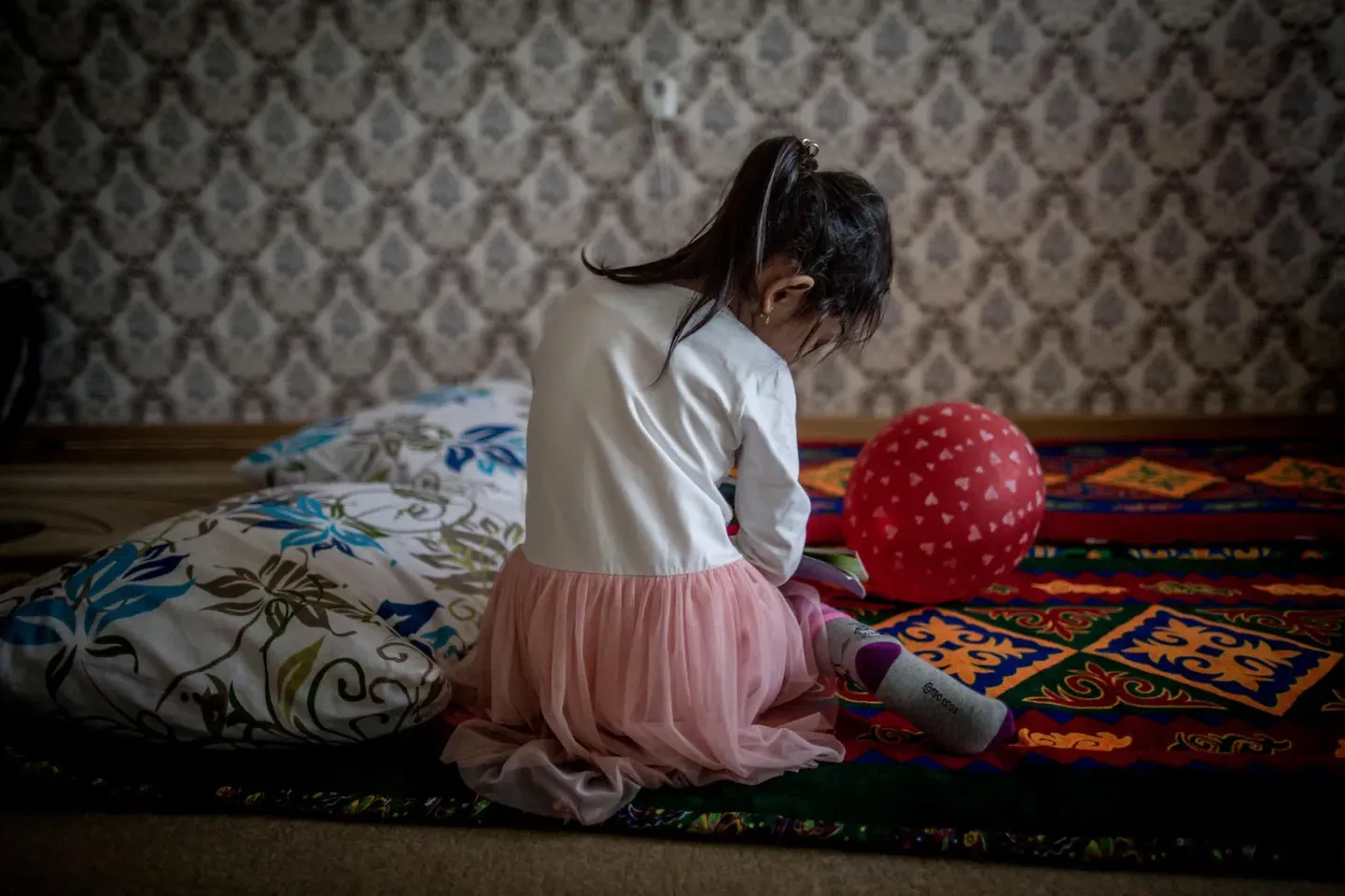 Anelya, age 5, plays in the living room of her family's apartment in Kyzylorda, Kazakhstan.