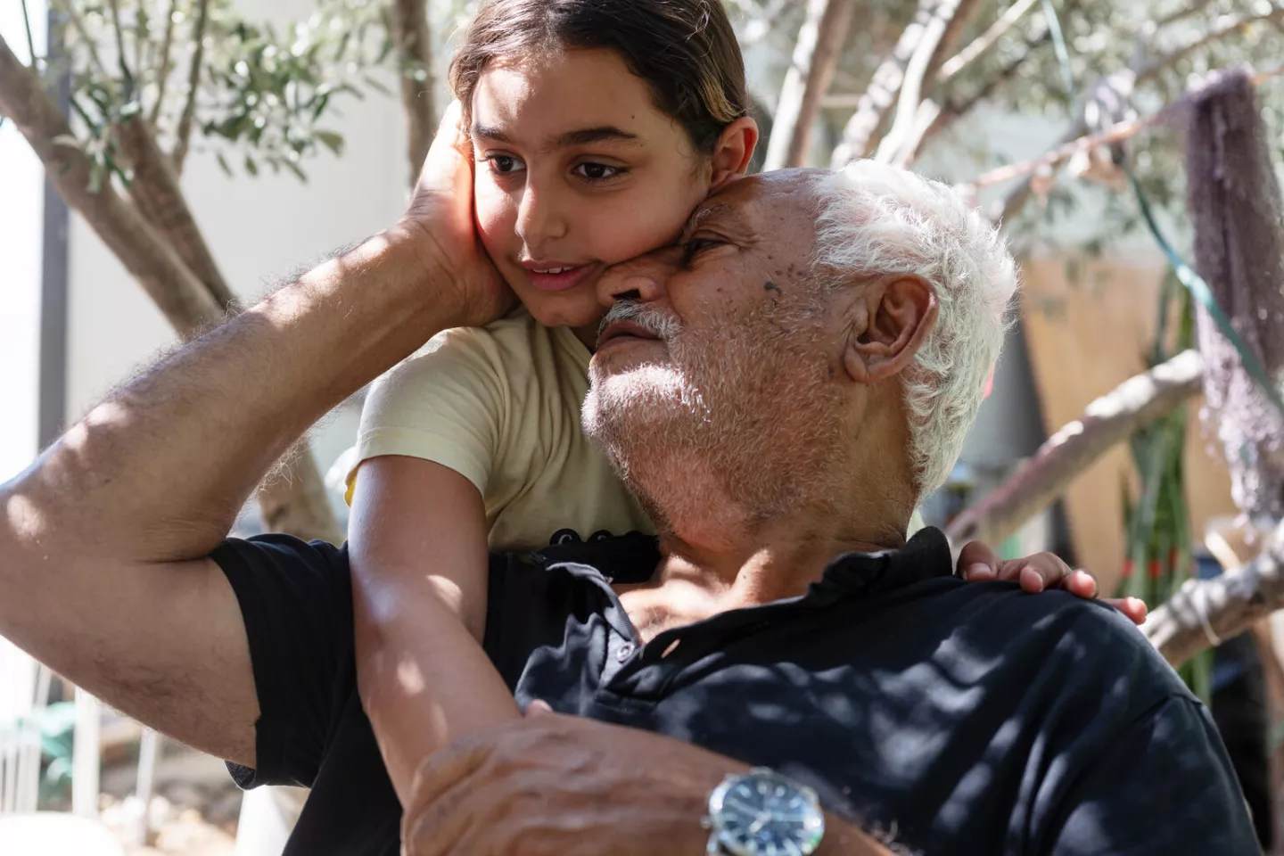 Sidra (10) hugs her grandfather Hassan (75).