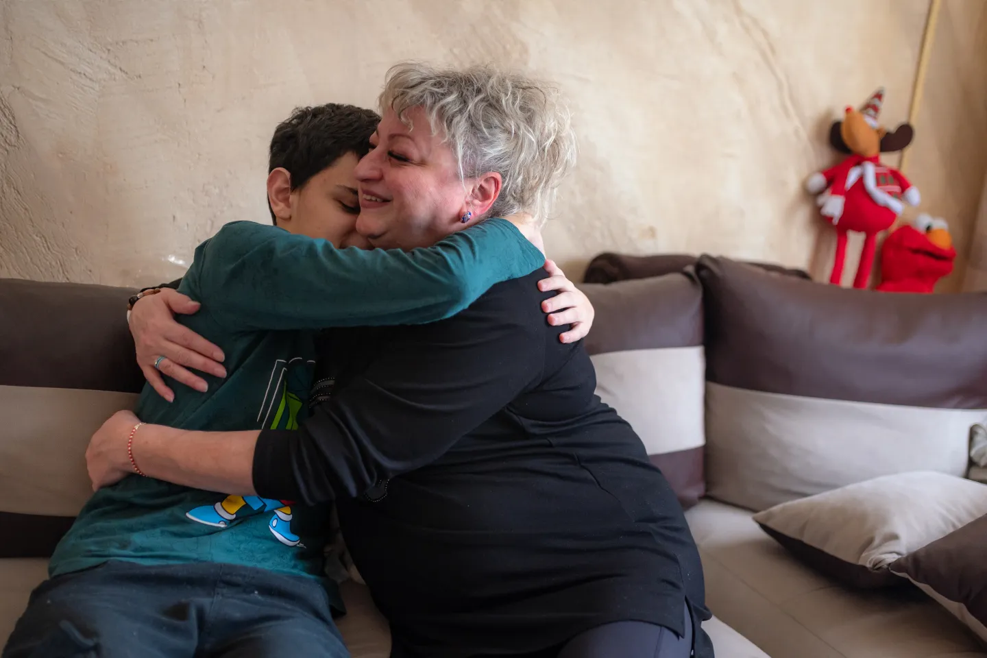 A foster mother and a child embrace. 